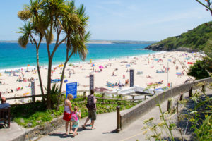 Family walking from St Ives railway station to Porthminster Beach