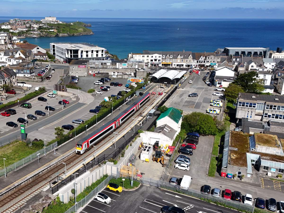 Drone photo of train in Newquay station with sea in background
